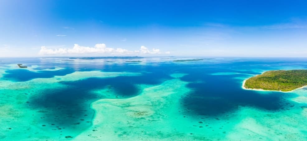 蓝绿色海水与海岛边缘的珊瑚礁海域